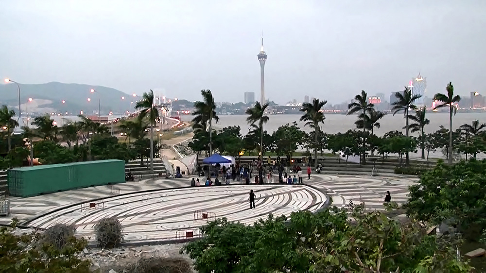 「澳門國際表演藝術中心」計劃建於「新城C區」，該地段為近10年來的填海用地，從未使用，2012年澳門藝術工作者曾發起「送海︰海洋文化交流計劃」回應澳門填海造地對環境的影響。圖為「送海」計劃的其中一場詩與音樂的演出，由再拒劇團、澳門演員林偉彤演繹澳、台兩地詩人作品，地點即為將填成「新城C區」的海岸線上。