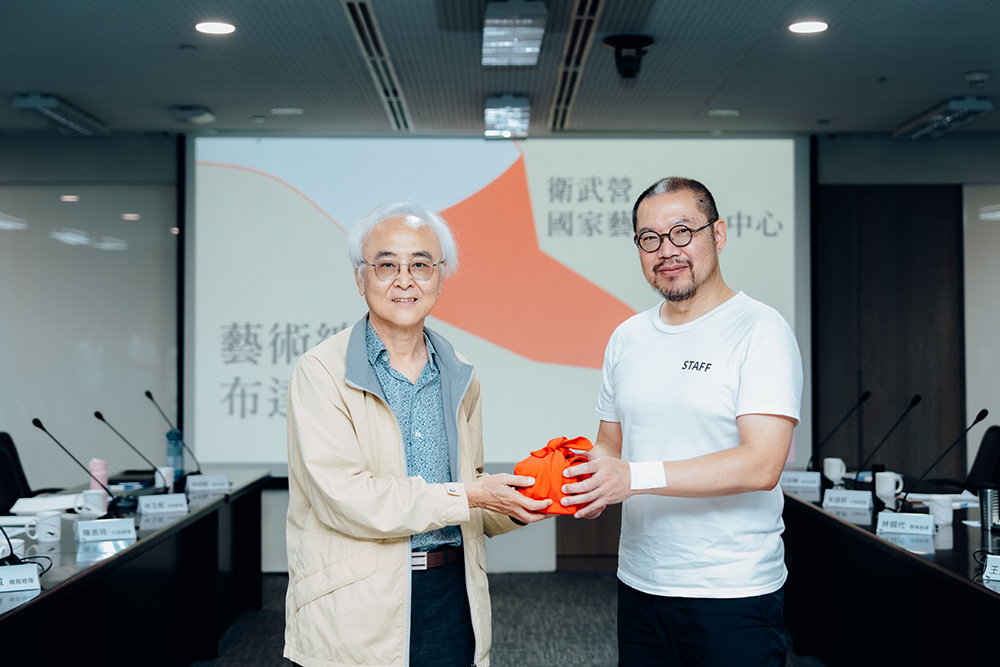 國表藝董事長楊其文（左）遞交印信予衛武營藝術總監簡文彬（右）。